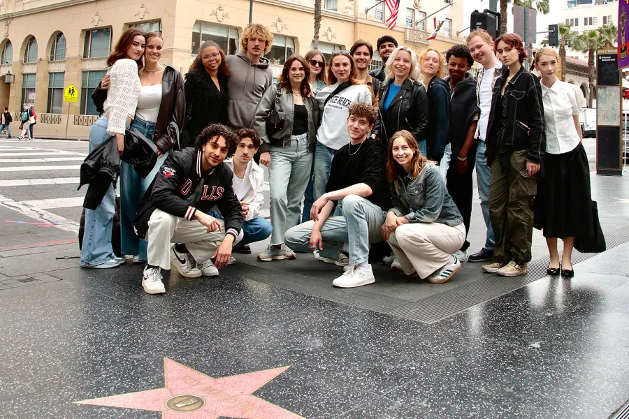 Teilnehmende posieren gemeinsam auf dem Hollywood Walk of Fame neben einem Stern